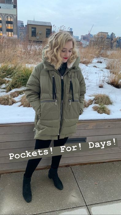 Mytour Editor Maitland Quitmeyer is seen wearing an army green parka with large pockets outdoors