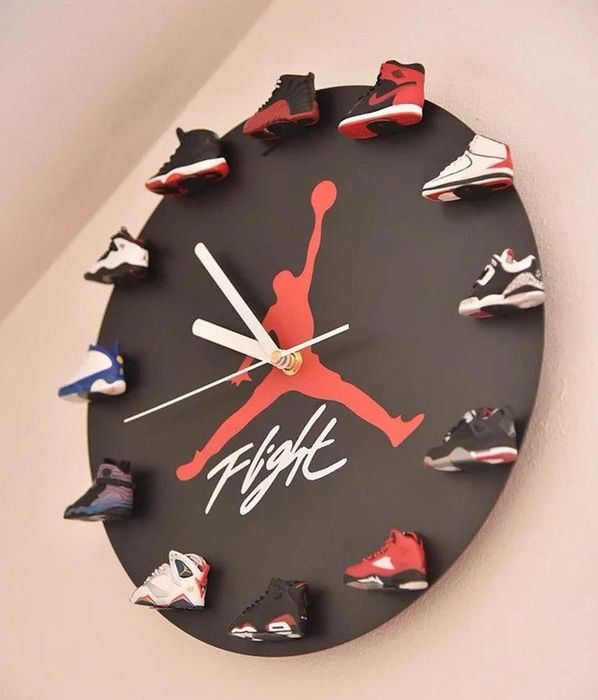 The clock showcases a red Jordan logo in the center with the word "flight" and 3D mini sneakers around the edge, representing Air Jordan numbers 1–12
