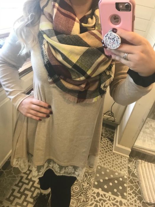 Reviewer wearing a scarf in beige, black, and red tones