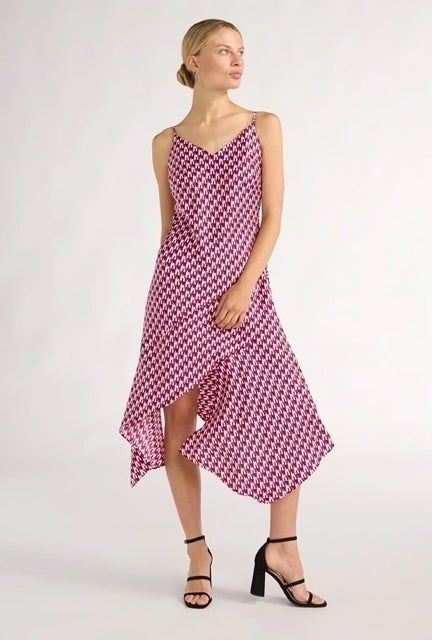 The model is seen wearing the dress paired with sleek black strappy heels.