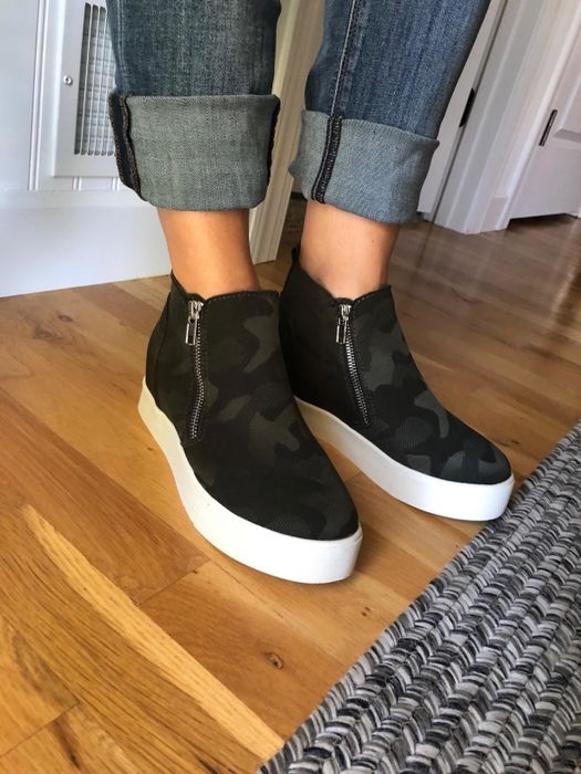 Reviewer is seen wearing camo-print platform sneakers with rolled-up denim