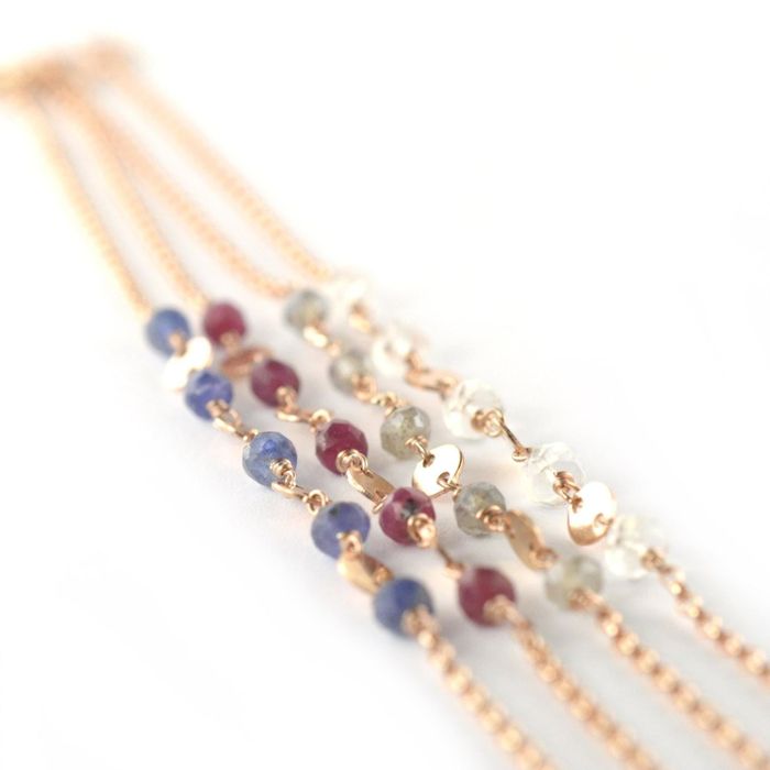 Four rose gold bracelets, each adorned with different birthstones