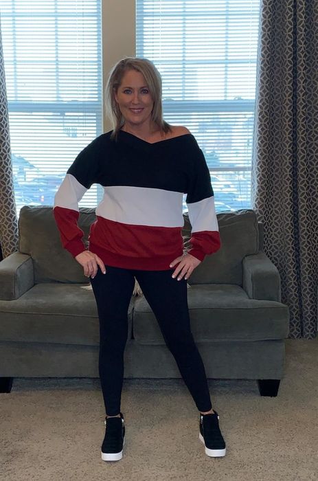 Reviewer wears the same platform sneakers with a striped sweater and black leggings