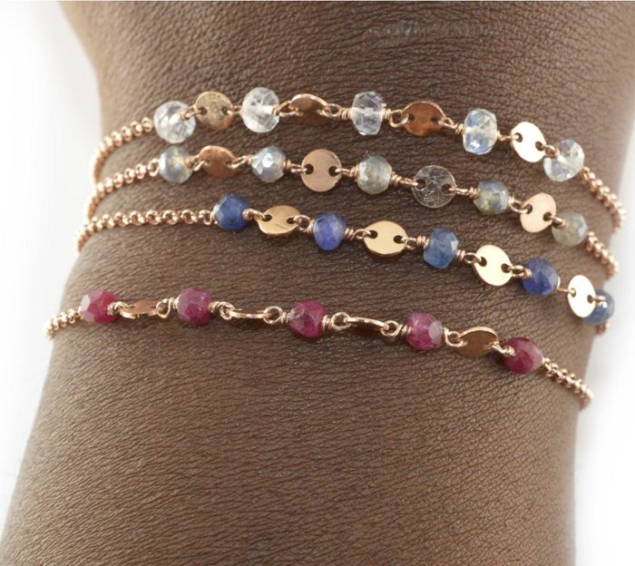 Model showcasing four rose gold bracelets, each featuring different birthstones