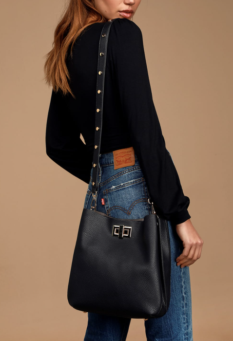 Model with a black tote bag draped over her arm