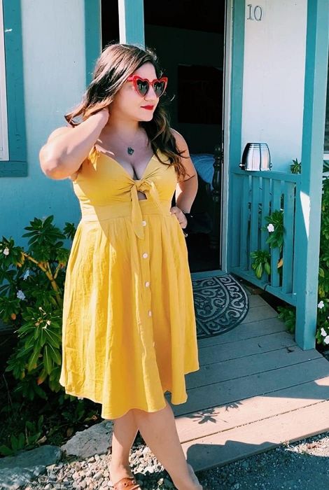 The reviewer is seen wearing a vibrant yellow dress.