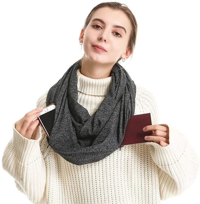 Model wearing an infinity scarf, demonstrating how to store a phone and passport in the side pockets