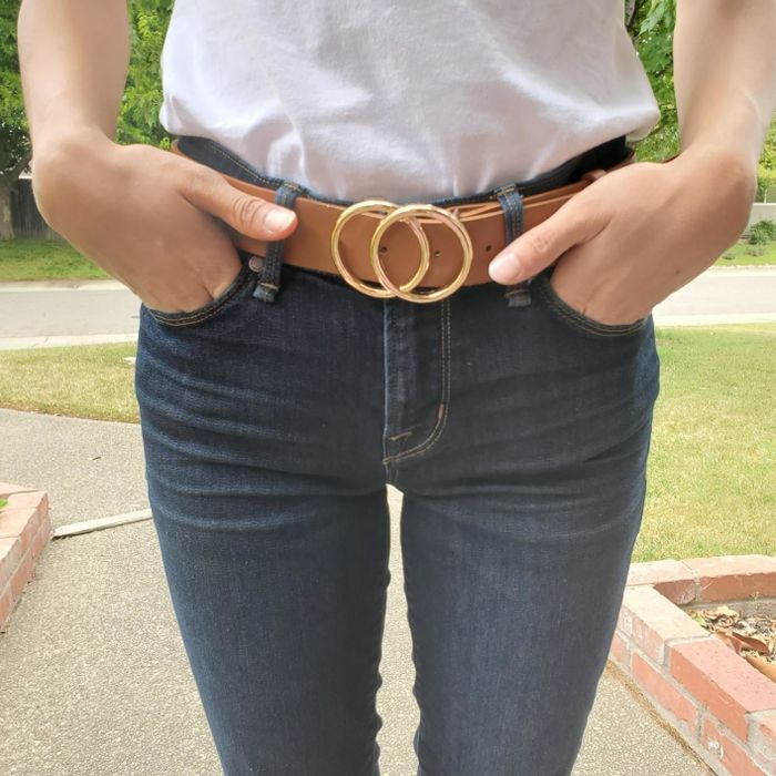 Reviewer showcasing a brown belt with gold overlapping buckles
