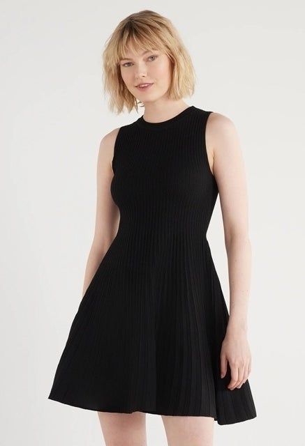 The model is wearing the dress, showcasing its chic design.