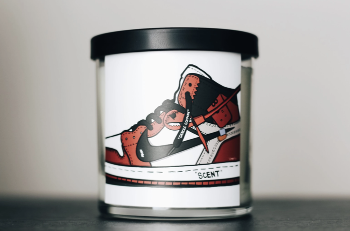 The candle features an image of a red, black, and white Air Jordan 1 sneaker