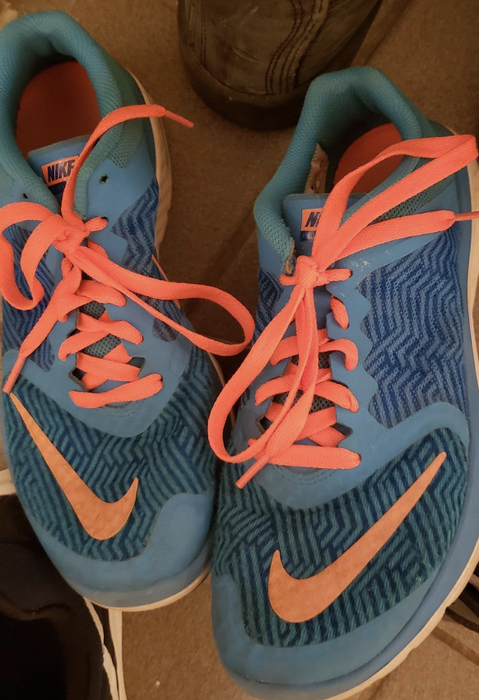 A reviewer’s sneakers featuring bright orange laces
