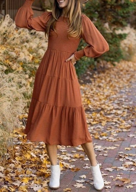 The model is wearing the dress paired with trendy white ankle boots, completing the perfect fall look.