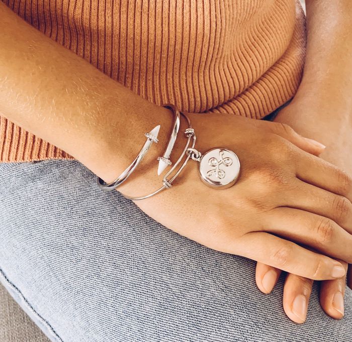 A model is wearing a silver expandable bracelet