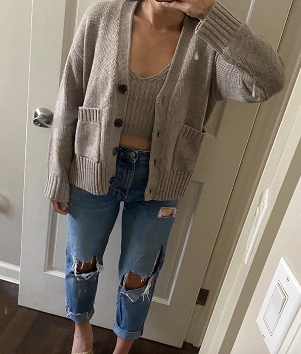 A reviewer wearing the light gray button-up cardigan