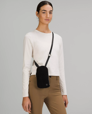 model wearing the black fleece crossbody bag