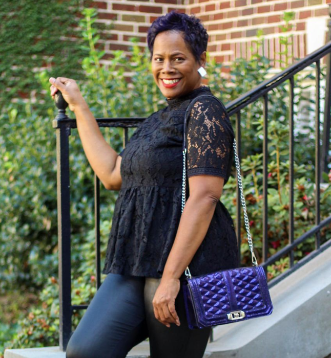 A reviewer wearing a black lace high-neck top
