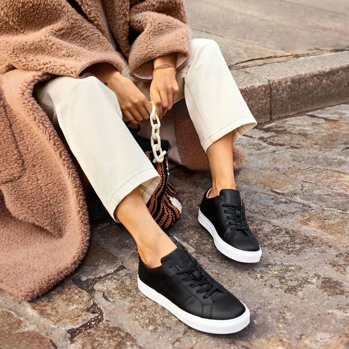 A model wearing black and white sneakers