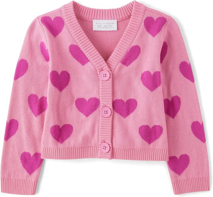 A pink kids’ cardigan covered in tiny pink hearts