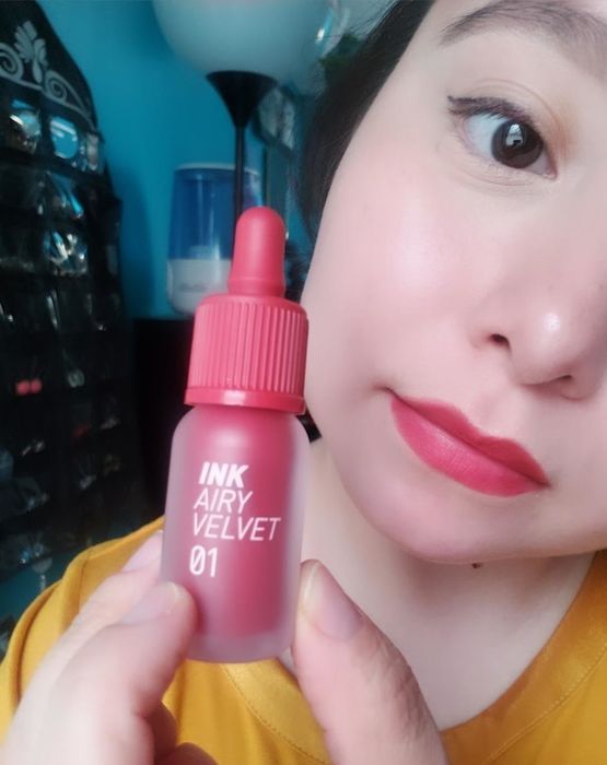 Another reviewer wearing the red shade and holding the product