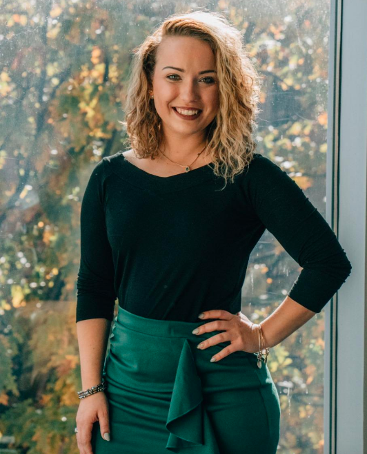 A reviewer wearing the stylish black off-shoulder top