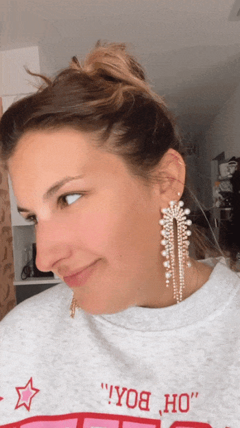 gif of Ali wearing the classic pearl rainbow dangly earrings