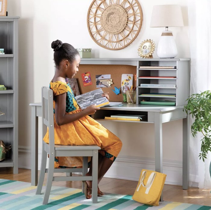 a child seated at a gray desk