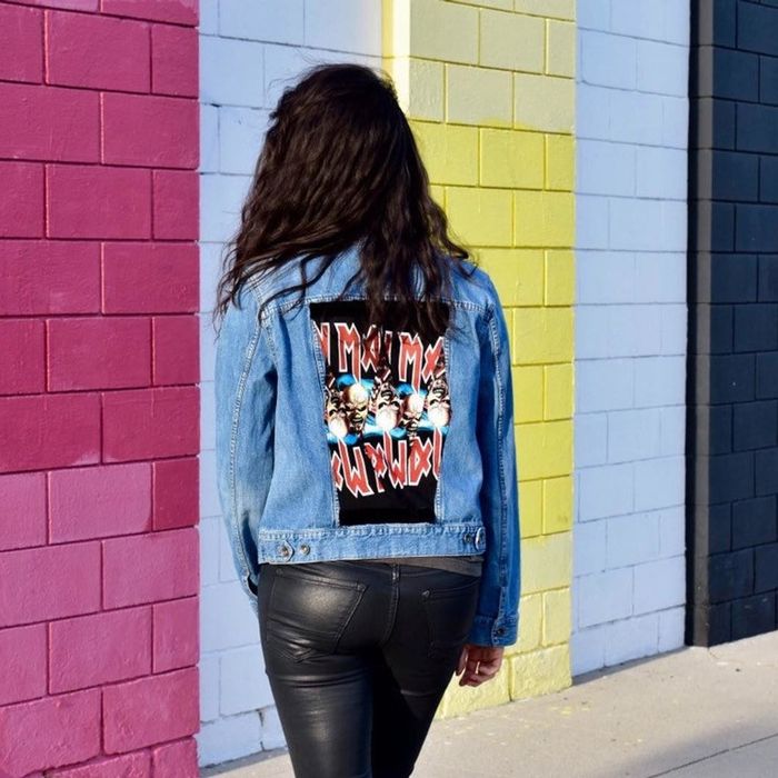 A model wearing a denim jacket with an Iron Maiden patch on the back