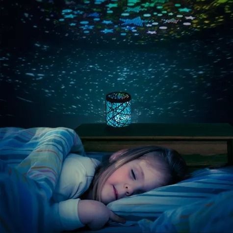 a child sleeps while a nightlight projects stars