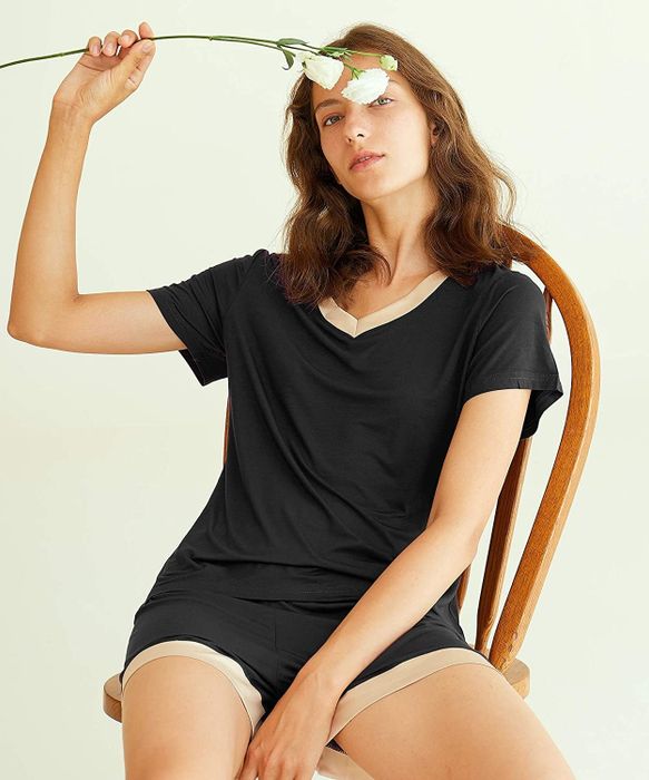 A model wearing a black V-neck tee and shorts