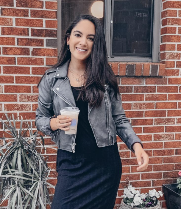 A reviewer wearing a gray faux leather jacket