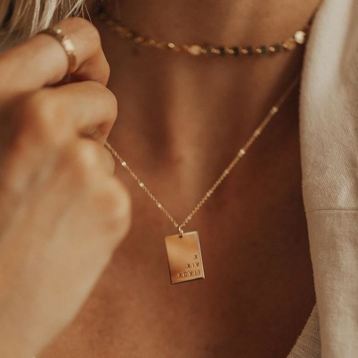A model wearing a customized gold pendant