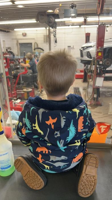A reviewer’s child wearing a fleece zip-up jacket with dinosaur prints
