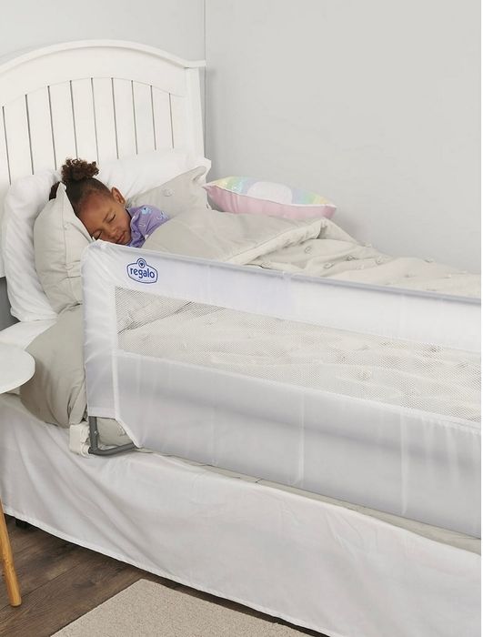 A toddler peacefully sleeping in bed, with a white mesh safety rail securely installed along the side to ensure safety while they sleep.