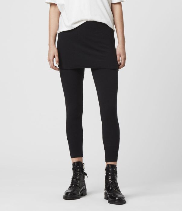 A model wearing black leggings paired with a skirt overlay