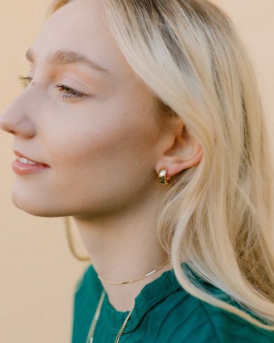 model wearing the gold huggie earrings