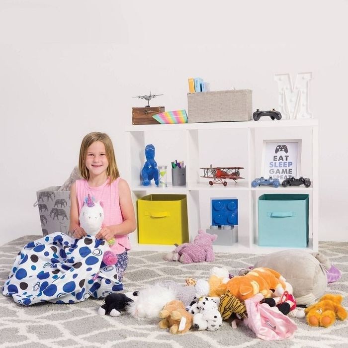 a child model places stuffed animals into a storage bag