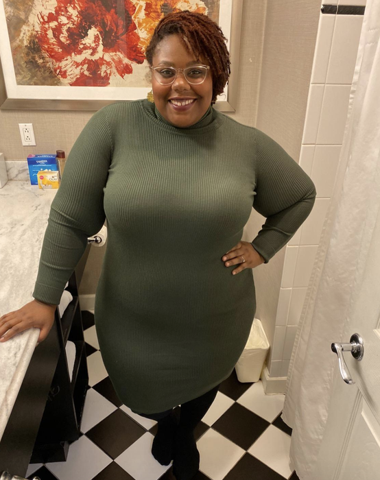 A reviewer wearing the olive green dress