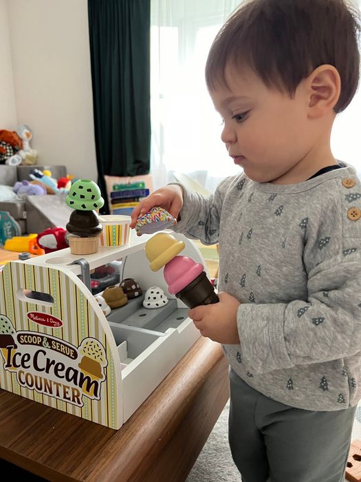A toddler wearing a cozy gray quilted sweatshirt with tiny tree designs and matching greenish-blue pants