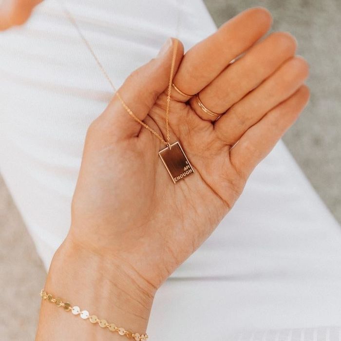 A model holding a gold pendant