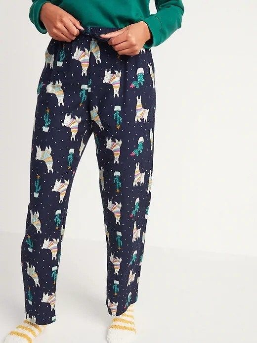 A woman sporting blue and green pajama pants adorned with llamas.