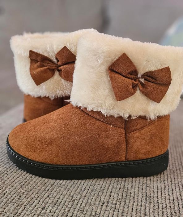 A close-up shot of a reviewer’s kids’ faux fur-lined winter boots