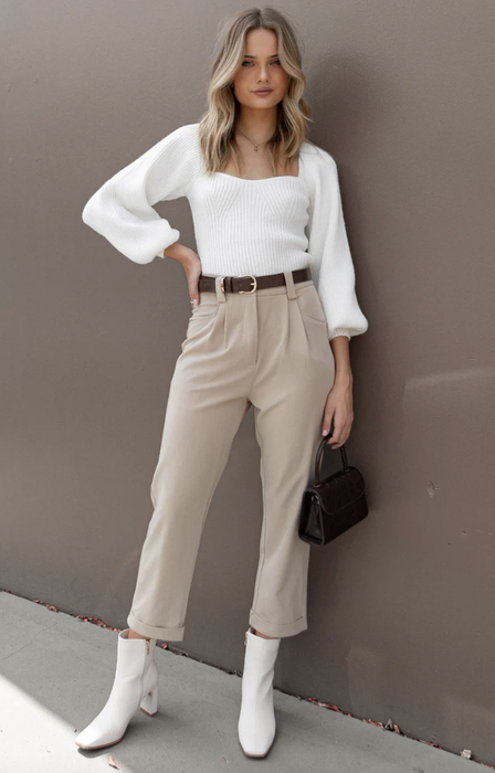 model wearing beige pants with a white top