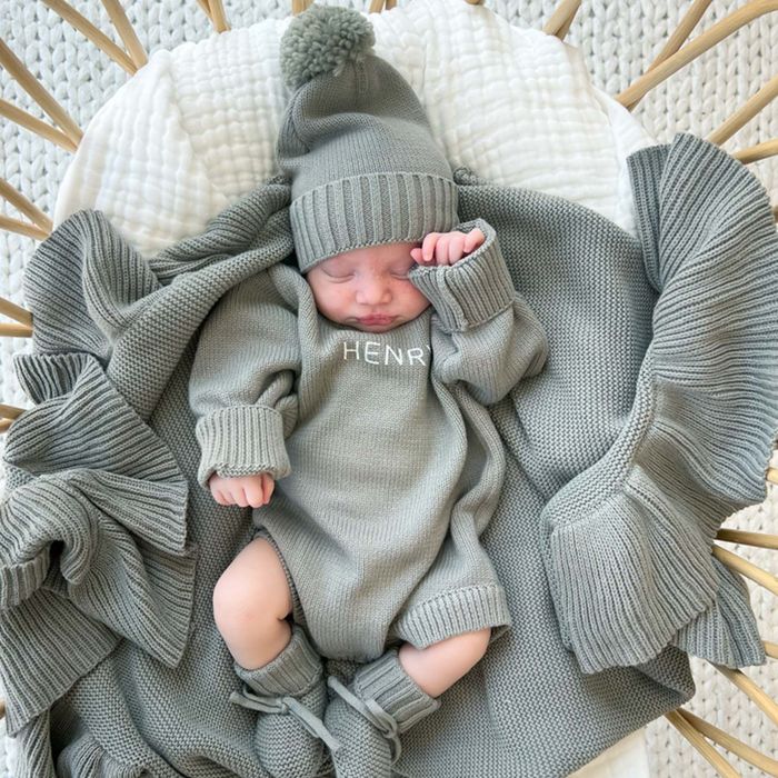 An infant wearing a blue-grey personalized sweater romper