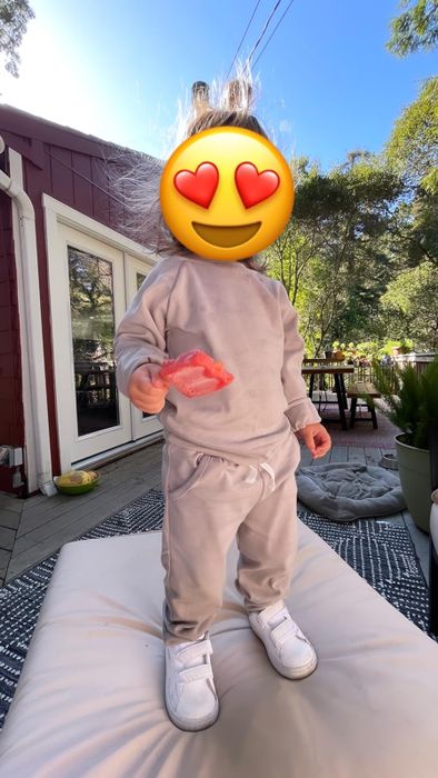 A reviewer’s toddler wearing a stylish tan sweat set