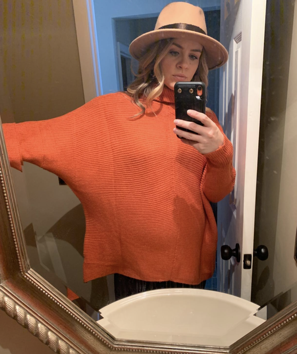 A reviewer wearing the orange sweater