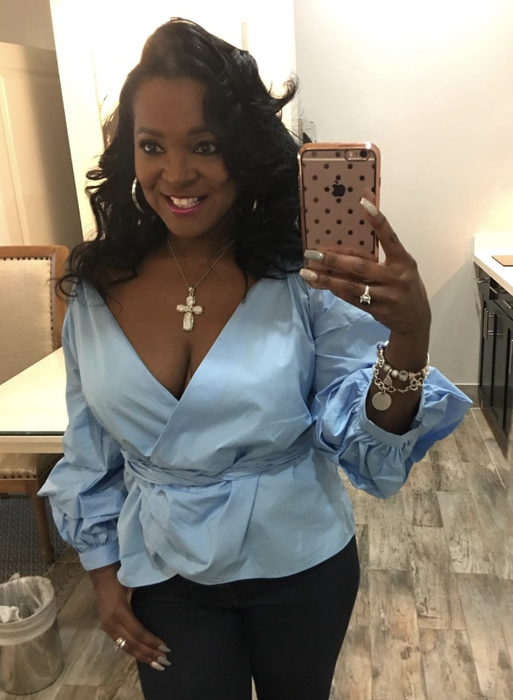 A reviewer wearing the blue V-neck wrap top