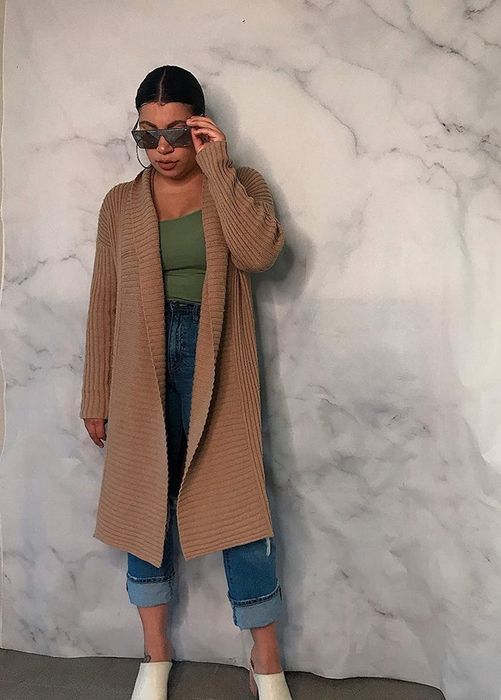 A model showcasing the brown midi-length jacket