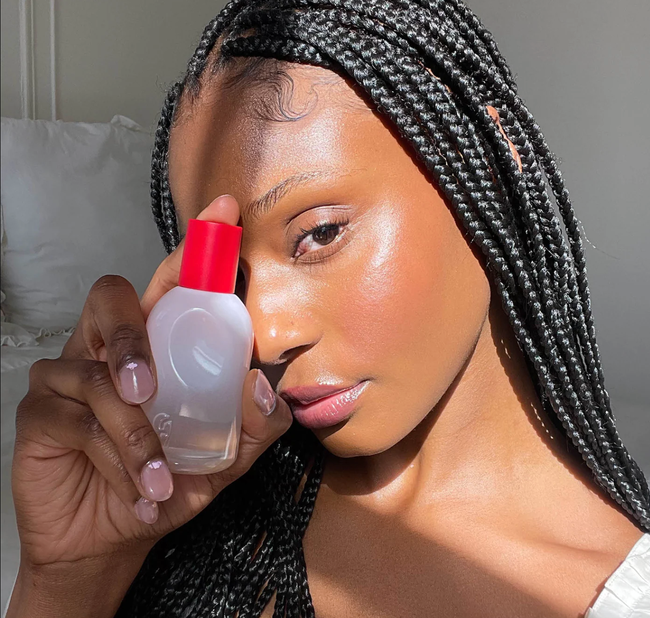 photo of a model holding Glossier's perfume bottle