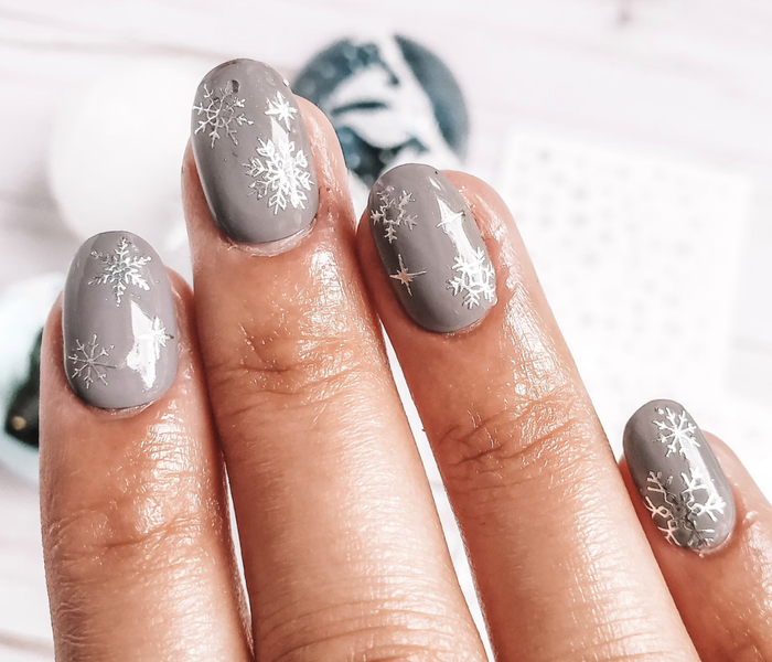 model showcasing silver-gray snowflake nail wraps