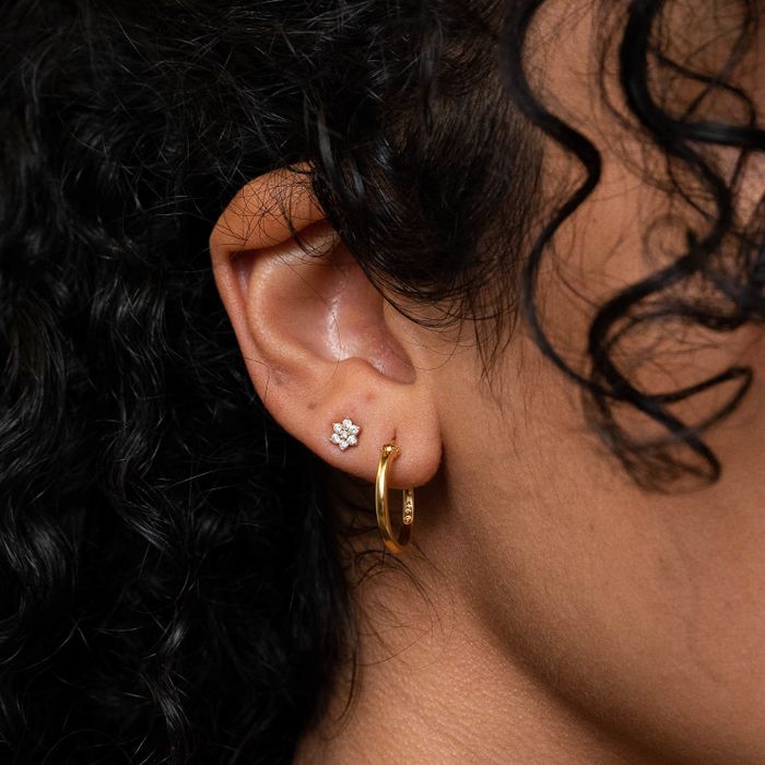 A model showcasing gold hoop earrings